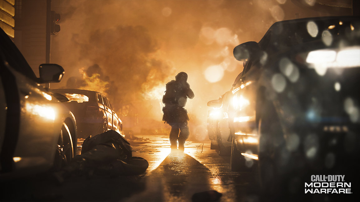 Call of Duty Modern Warfare screenshot showing a soldier approaching a fire through a city street with abandoned cars on both sides
